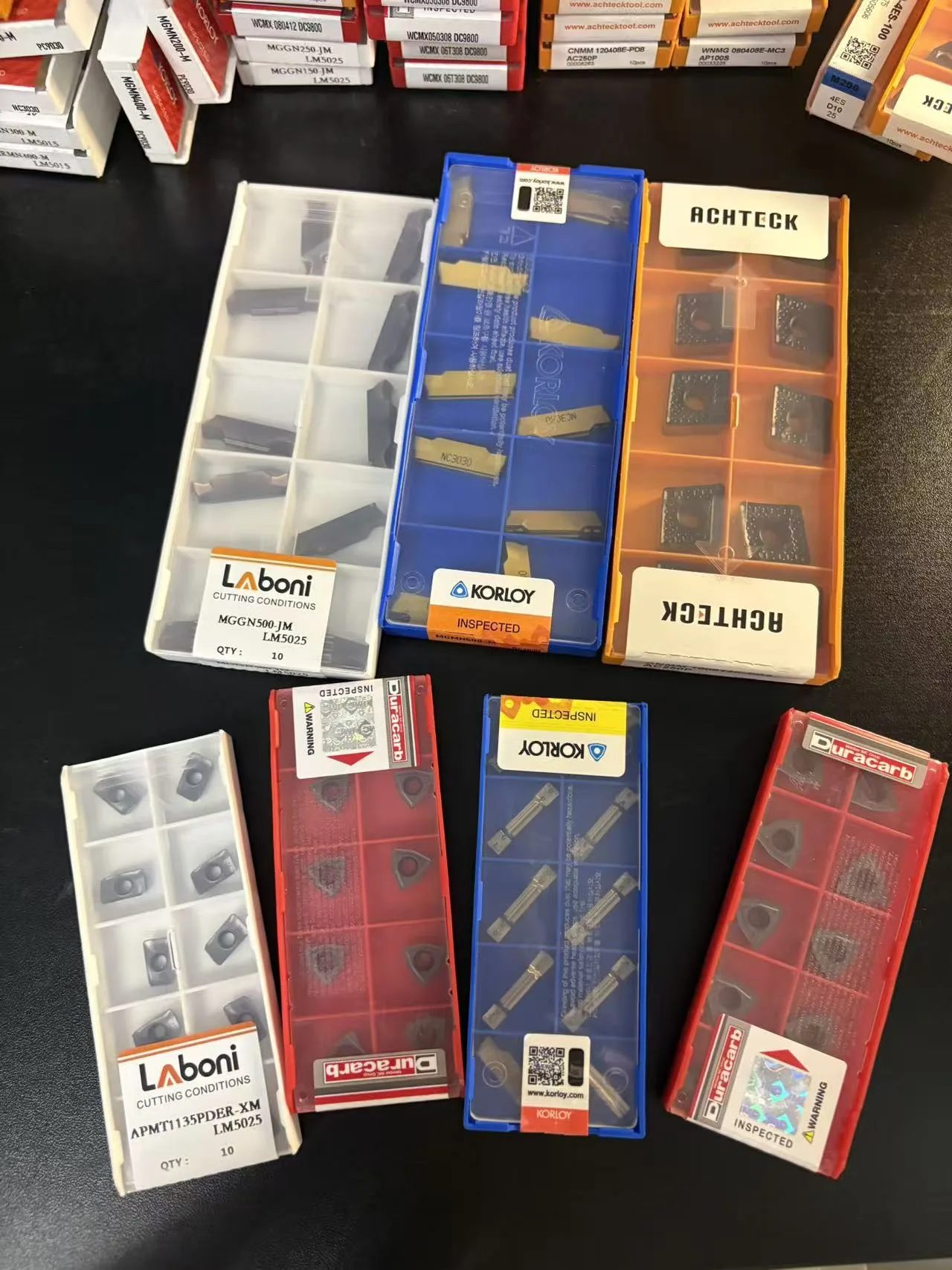 Flat lay of indexable insert boxes from multiple brands
